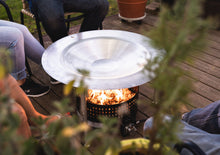 Load image into Gallery viewer, Friends gathered around a fire pit featuring HeatSaver heat deflector
