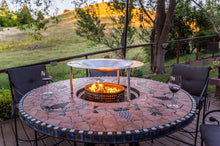 Load image into Gallery viewer, HeatSaver fire pit heat deflector on a patio table, wine glasses nearby

